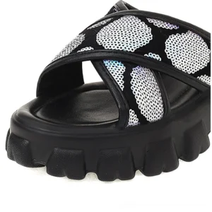 Close-up top view of holographic iridescent sequin details on black platform sandal slide with thick cushioned base