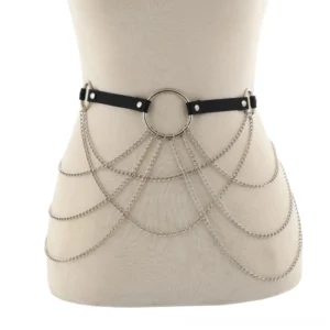 Mannequin display of black leather waist harness with draped silver curb chain and central O-ring detail close-up