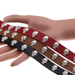 Multiple color variants of leather skull chokers displayed in studio overhead view, showcasing silver metal skull decorations and adjustable buckle designs