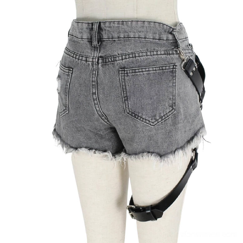 Gothic PU leather harness rear view showing single thigh strap and silver fixtures on grey frayed denim shorts