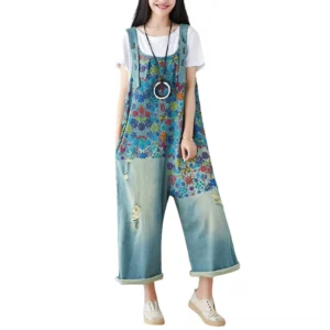 Light blue floral denim wide-leg overalls worn by model, front full view with rolled cuffs and layered styling, showcasing the botanical print and relaxed silhouette