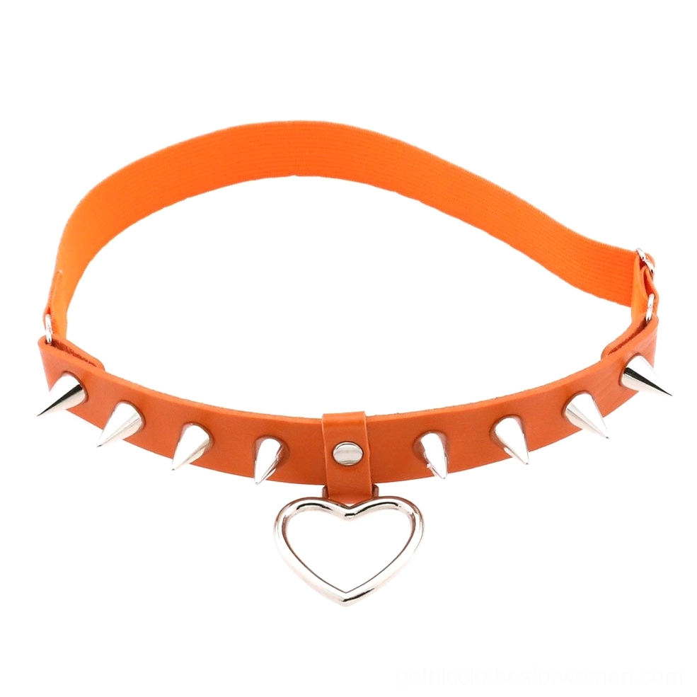Orange elastic leg garter with silver spikes and heart pendant, alternative fashion body jewelry flat lay