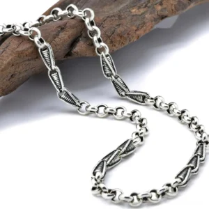 Oxidized sterling silver gothic link chain necklace with twisted vintage links and darkened patina, close-up side view on wooden surface