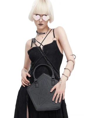 Goth model wearing black pentagram crossbody bag with full-body front view, styling with heart-shaped sunglasses and alternative gothic outfit
