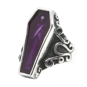 Purple coffin mummy stainless steel ring front angle showing carved scroll details and coffin-shaped setting