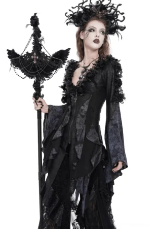 Black raven cross ritual staff with layered chains and rose accents displayed on model wearing asymmetrical gothic dress, right side angle