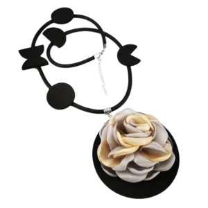 Two-tone rose pendant gothic necklace flat lay oblique view with silver metal extension chain on white background, showing black geometric rubber accents and adjustable closure