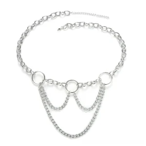 Flat lay display of layered statement chain belt with extended tail chain and circular ring accents on white background