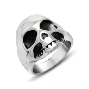 Polished silver stainless steel memento mori skull ring with intricate hollow eye sockets and fang teeth detail, 3/4 front studio view showcasing gothic punk statement jewelry