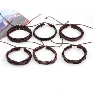Six-piece brown leather goth wristband collection flat lay display with magazine prop showing dark brown dual design variants with adjustable pull-tie closures