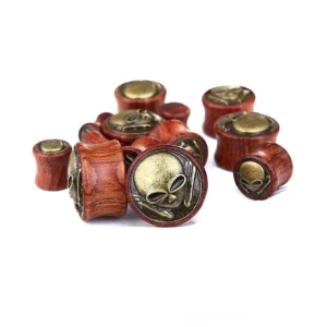 Multiple sizes of skeleton skull wooden flesh tunnels displayed overhead and side angles, showing complete range from 14mm to 30mm diameter gauges with bronze skull emblem