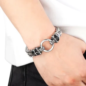 Men's skull bracelet worn on wrist, side angle showing silver tone wheat link chain with skull clasp mechanism