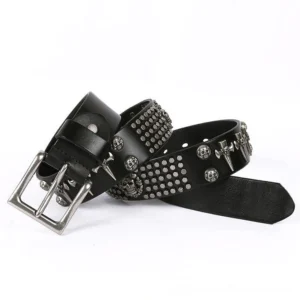 Punk rock leather belt with silver skull buckle and studded trim detail flat lay photography