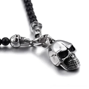 Close-up side view of polished silver skull pendant with intricate carved details on stainless steel chain