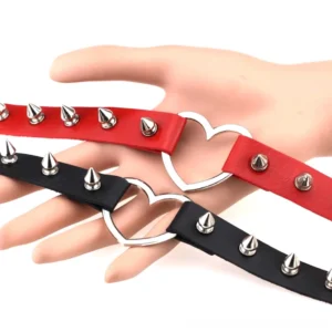 Gothic spiked leather choker with heart buckle displayed on mannequin hand, showing adjustable snap holes and silver metal spike detailing