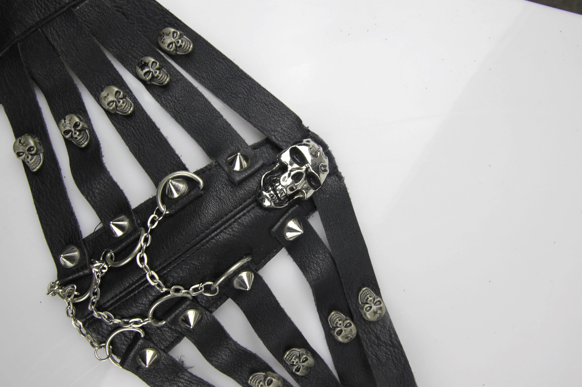 Angled flat view of black steampunk gothic face mask highlighting black leather texture, skull and spike studs, metal chains and hardware detail