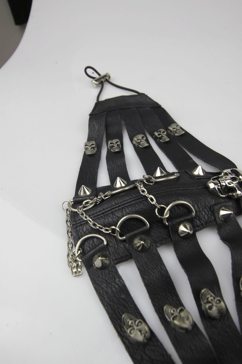 Flat lay angled view of black steampunk gothic face mask showing leather construction, skull studs, hanging metal chains and adjustable neck strap