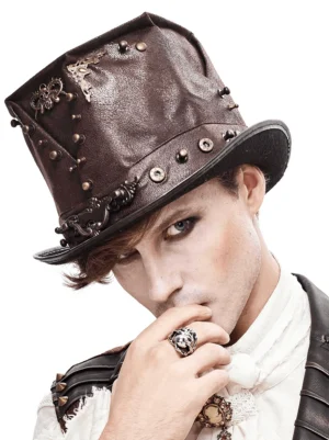 Male model wearing brown leather steampunk top hat with skull metal ornament and rivets, three-quarter front view showing detailed metalwork and vintage aesthetic