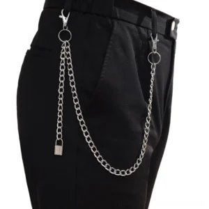 Twisted silver gothic chain accessory with rectangular charm pendant on black trousers, punk style dual-layer design