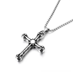 Detailed side angle of vintage cross pendant showing intricate scrollwork carving and polished silver finish