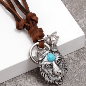 Antiqued silver wolf head pendant with turquoise details on brown leather cord, three-quarter side view displaying intricate craftsmanship and adjustable knotted design