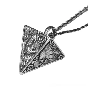 Vintage pyramid sterling silver pendant with embossed animal motifs, left oblique view on white background showcasing gothic jewelry design