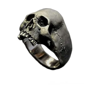 Vintage skull ring in aged silver zinc alloy with detailed textured design and exposed teeth, front oblique view