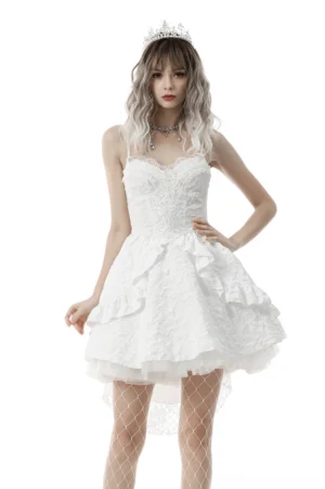 Front full-body view of white gothic hi-low wedding dress with jacquard embroidery, sweetheart neckline, ruffled short front skirt, and tiered lace layers on model wearing tiara and fishnet stockings