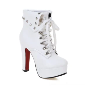 White studded platform ankle boots with gothic spike heel and lace-up closure, side profile displaying metallic hardware and architectural heel design