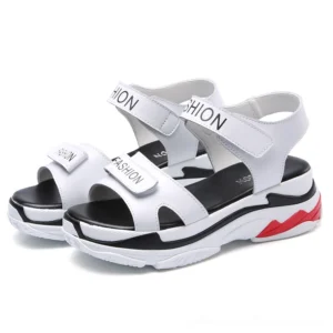 White platform velcro sandals with red sole accents, front three-quarter view showcasing smooth synthetic leather upper and branded lettering