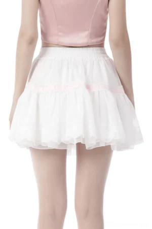 White gothic pleated mini skirt rear view showing elastic waistband and pink ribbon trim on ruffled hem