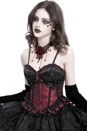 Female goth model wearing wine red gothic lace-up corset with ruffle trim, front studio shot with long black gloves and rose choker, showing form-fitting silhouette and lace-up closure details