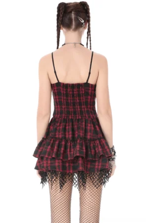Gothic tartan corset mini dress back view showing smocked elastic panel, layered ruffles, and fishnet lace detailing on model with braided hair