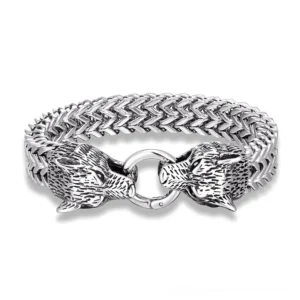 Wolf head gothic stainless steel bracelet flat lay top view showing dual carved wolf head clasp and wheat link chain on white background