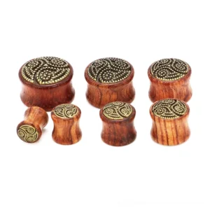 Wooden ear tunnel gauge side view displaying triskele symbol and vintage metal engraved top, natural wood texture and burgundy tone, gothic ear jewelry