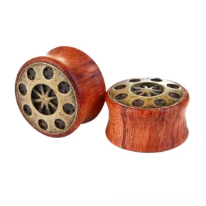 Wooden ear gauges flesh tunnel with ornate bronze star and circle cap details, double-flared design in warm orangewood tones, gothic body jewelry
