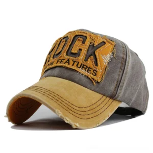 Yellow and brown distressed snapback cap front three-quarter angle showing embroidered rock appliqué and frayed edges